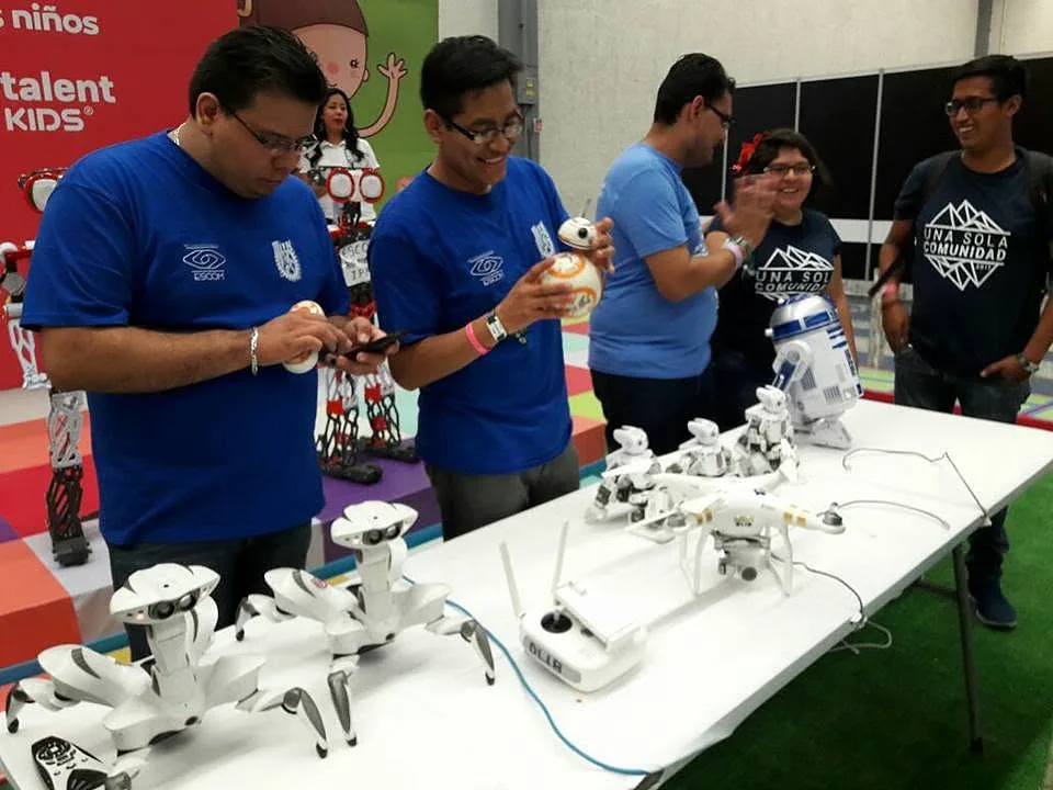 Equipo del club mostrando sus robots y drones en una mesa de demostración