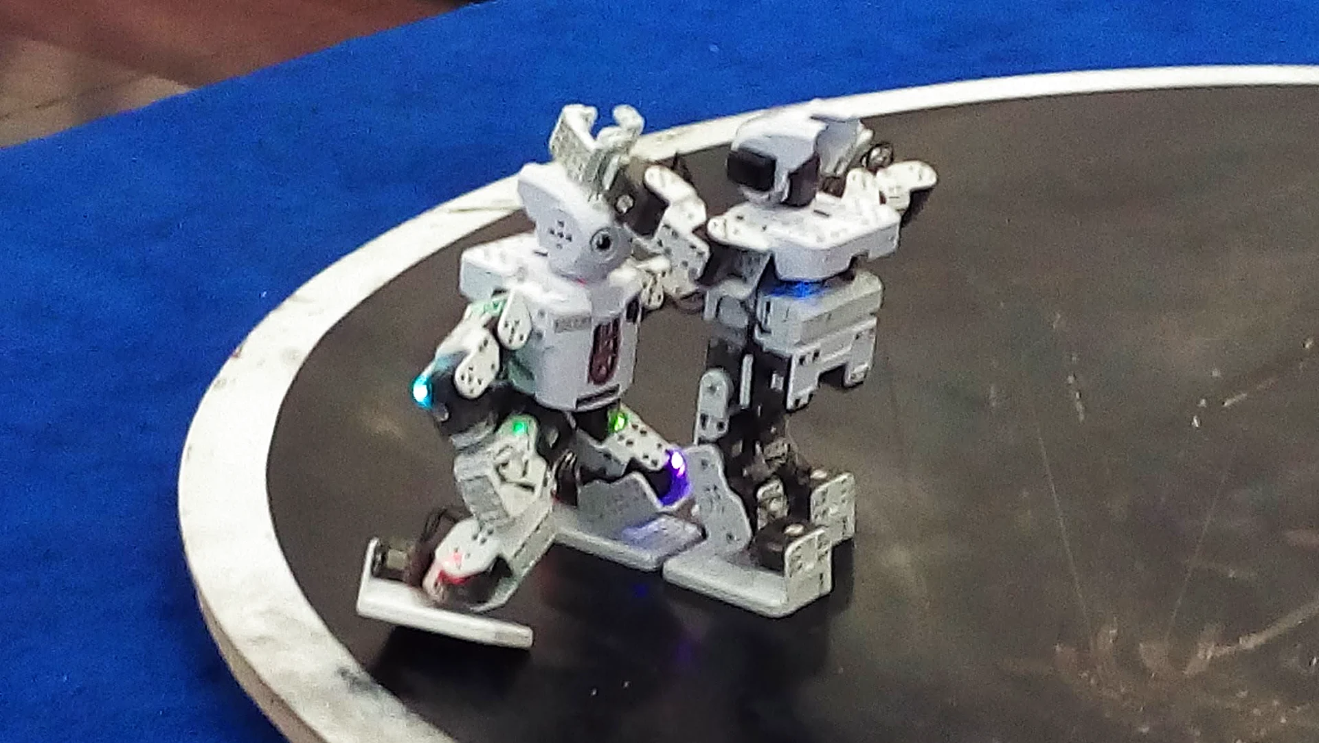 Robots humanoides del club con luces LED en combate
